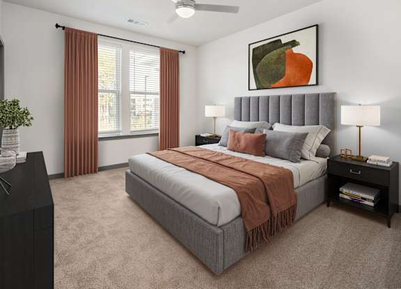 A bedroom with a large bed and a painting of a pumpkin on the wall.
