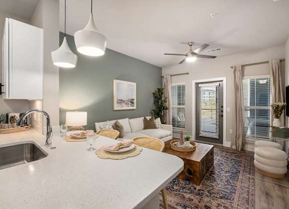 an open kitchen and living room with a white counter top