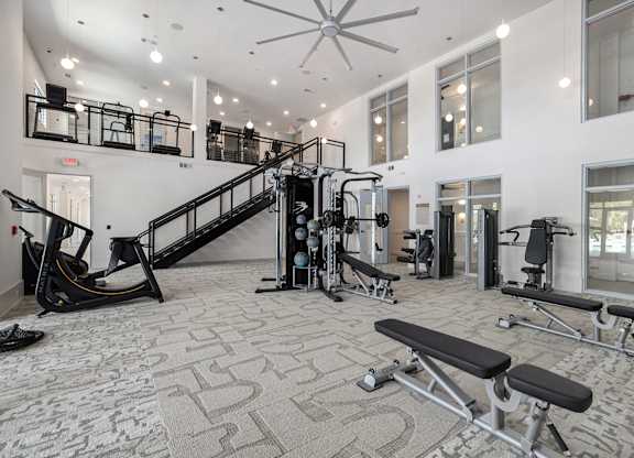 a gym with exercise equipment and a staircase