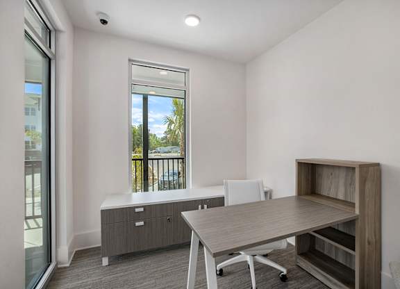 an office space with a desk and a chair and a window