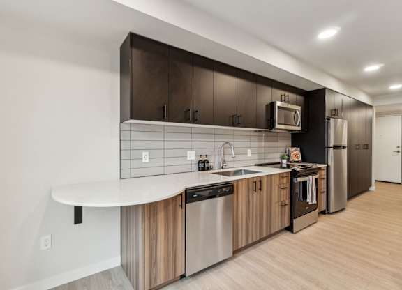 A modern kitchen with a white countertop and stainless steel appliances at Ion Town Center, 98133.