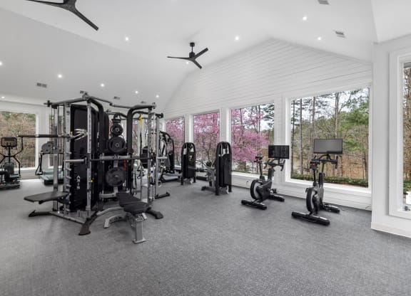 a gym with a lot of exercise equipment and windows