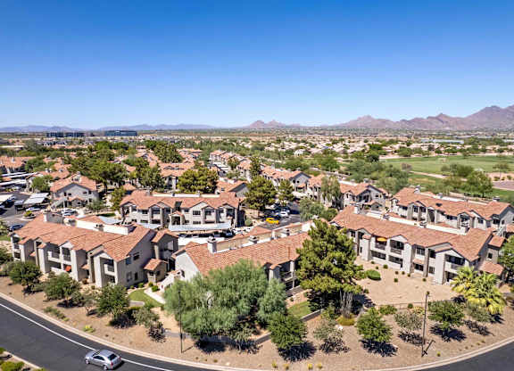 A residential area with houses and a car on the road.