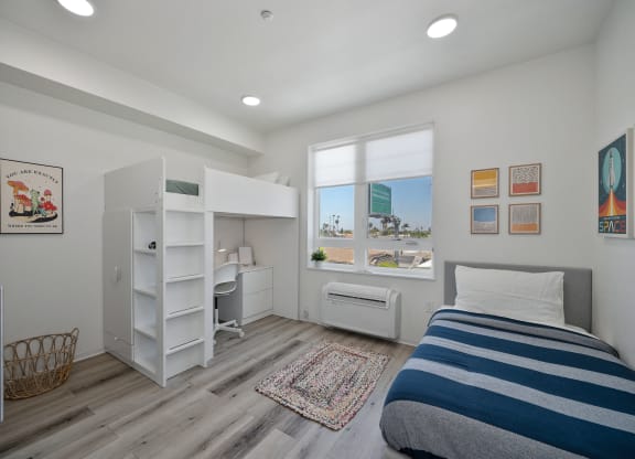 a bedroom with a bunk bed and a desk and a window