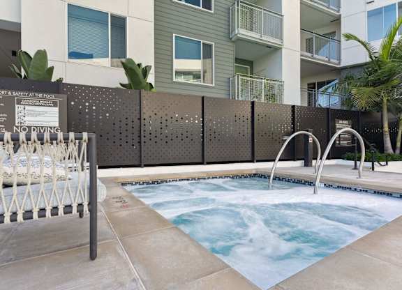 A hot tub is surrounded by a wall with a sign that reads
