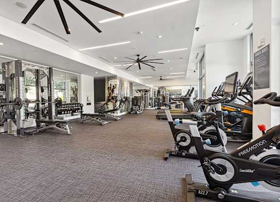 a spacious fitness center with cardio machines and other exercise equipment