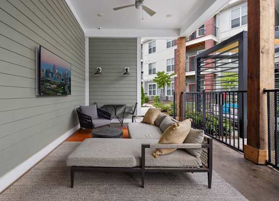 A balcony with a table and chairs and a painting on the wall.
