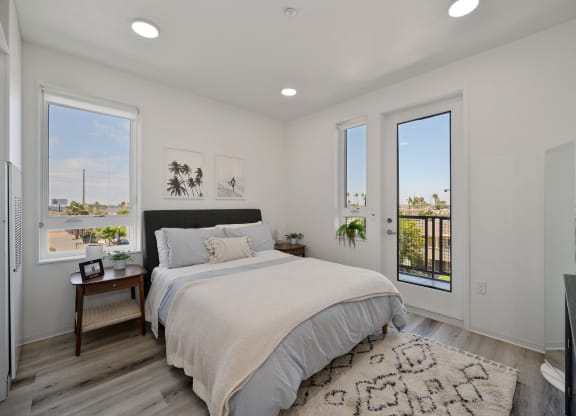 a white bedroom with a bed and two windows
