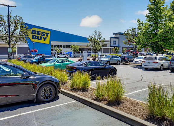 A Best Buy store with cars parked in the lot.