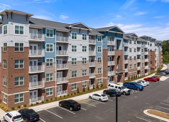 a large apartment building with a parking lot in front of it