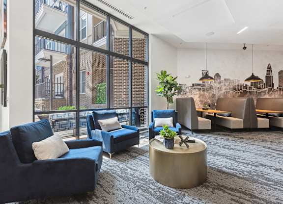 a large living room with blue couches and chairs and a large window