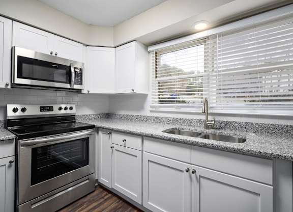 A modern kitchen with a stainless steel oven and microwave.