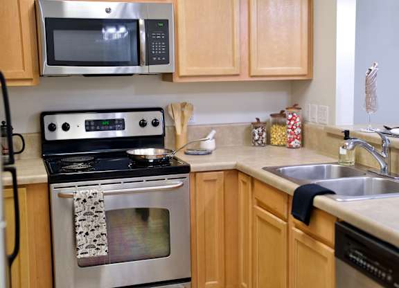 a kitchen with wooden cabinets and stainless steel appliances