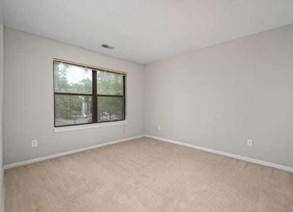an empty living room with a large window