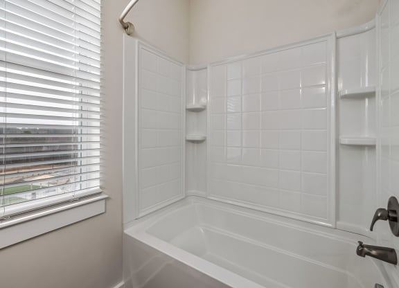vacant bathroom with built in tub shelves