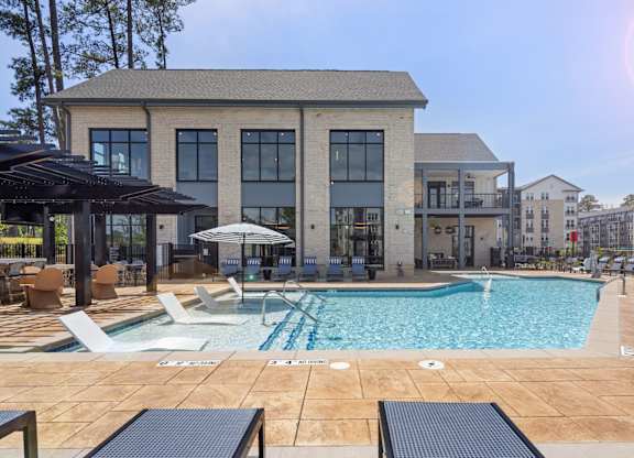 A large building with a pool in front of it.