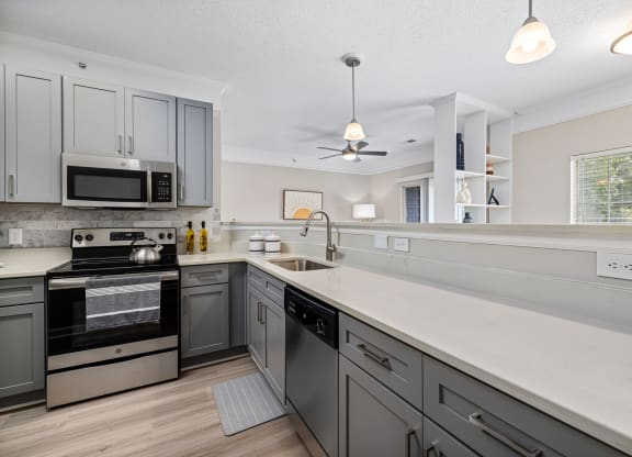 a large kitchen with white counter tops and stainless steel appliances at Mariners Crossing, North Carolina