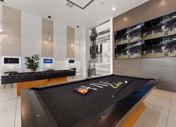 A pool table with a green felt cloth and a white cue ball and red balls.
