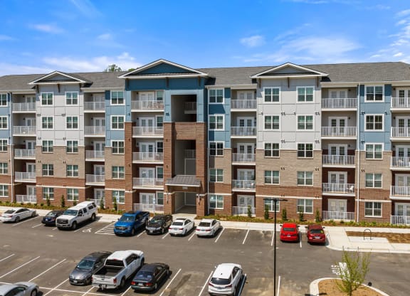 a large apartment building with a parking lot in front of it