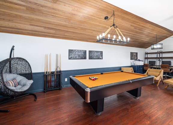 a game room with a pool table and a chandelier