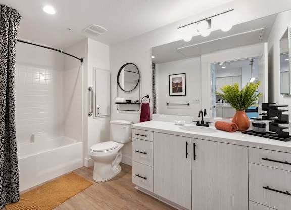 A bathroom with a white toilet, sink, and a mirror.
