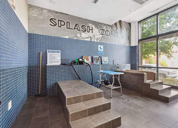 the entrance to thesplash zone with a bench and a table with a water hose