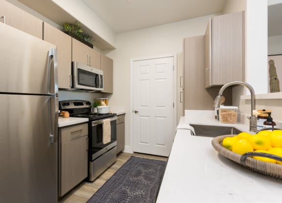 kitchen with stainless steel appliances at the district flats apartments in lenexa