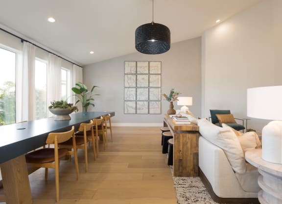 a living room and dining room with a long table and a couch