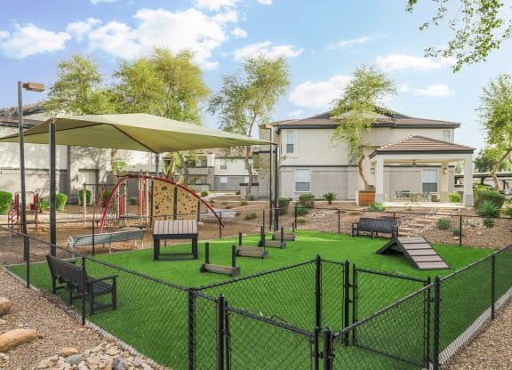 a fenced in play area with benches and umbrellas