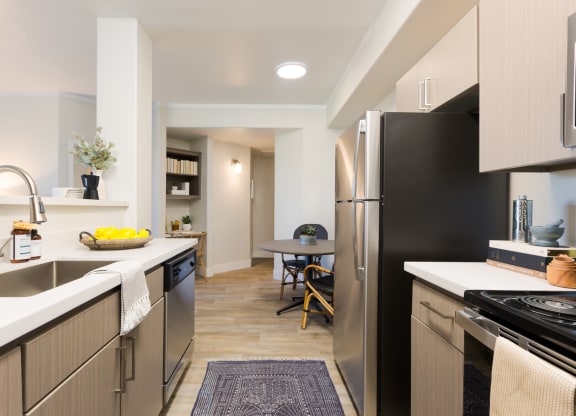 a renovated kitchen with stainless steel appliances and a dining room with a table