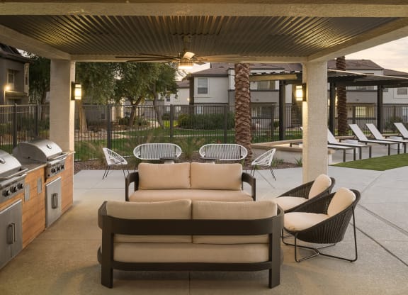 a patio with a couch and chairs and a grill