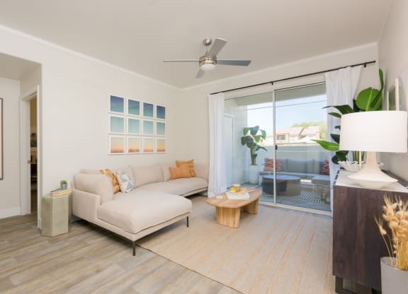 a living room with a white couch and a sliding glass door