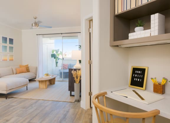 a living room with a white couch and a desk