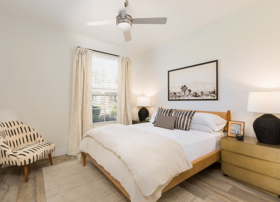 a bedroom with a bed and a chair and a ceiling fan