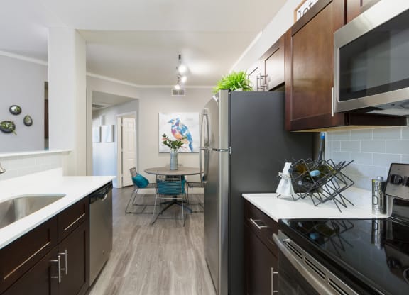 kitchen and dining room with stainless steel appliances at the district flats apartments