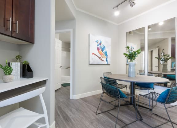 a dining room area with a table and chairs and a window