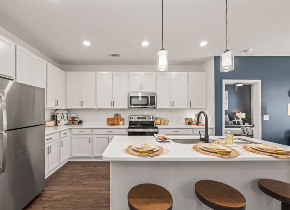 a large kitchen with white cabinets and a table