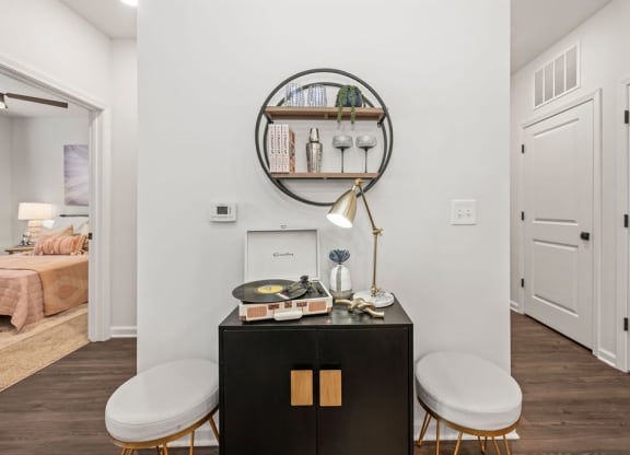 a living room with two stools and a table with a mirror