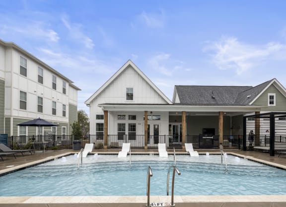 a swimming pool is in front of a building with a house