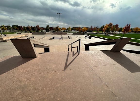 Skate park with ramps and a pole.