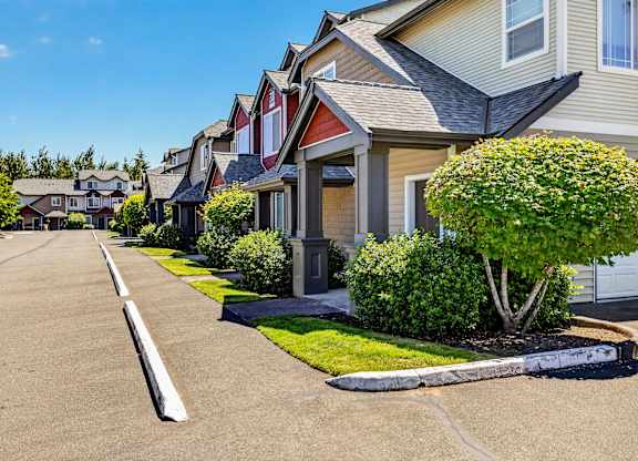 A row of houses with a tree in front of the first house.