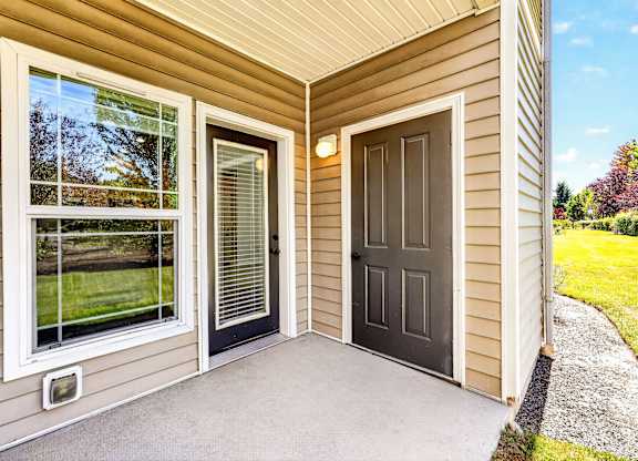 A house with a brown door and a window with blinds.