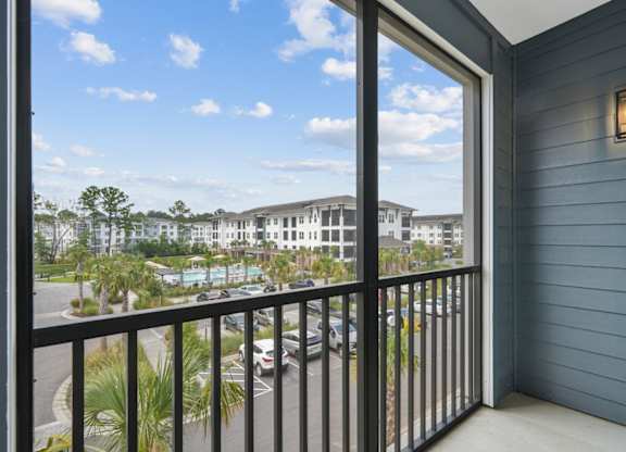 a balcony with a view of a building and palm trees