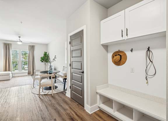 a living room with a door to a dining room and a table