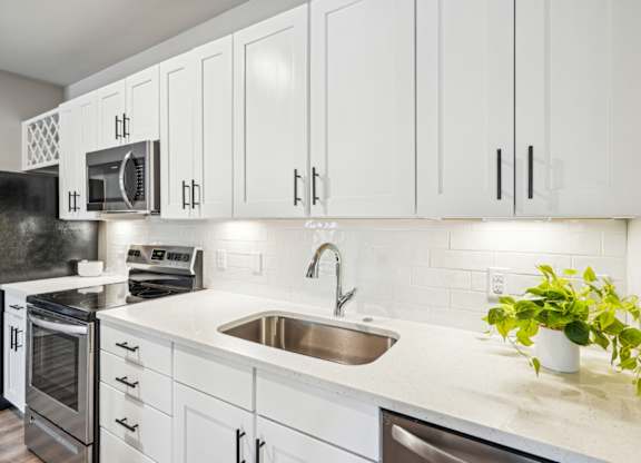 a kitchen with white cabinets and a sink
