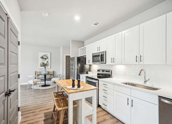 a kitchen with white cabinets and a floating island