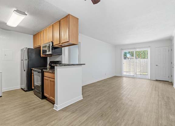 A kitchen with black appliances and wooden cabinets.