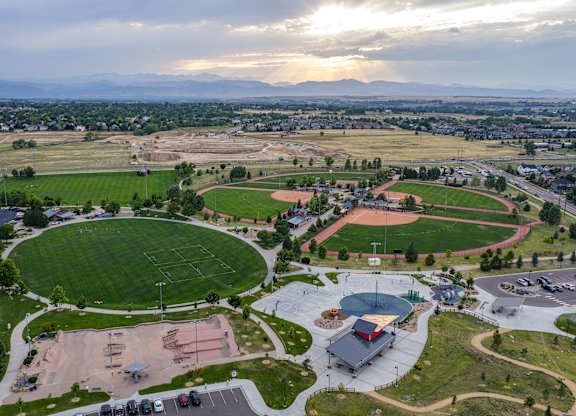 An aerial view of a sports complex with a large oval track and a basketball court.