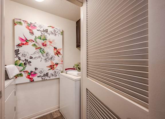 A small bathroom with a floral print towel hanging on the wall.