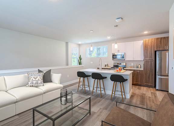 Modern kitchen with white cabinets and a breakfast bar at The Allaso Peak, Colorado, 80907